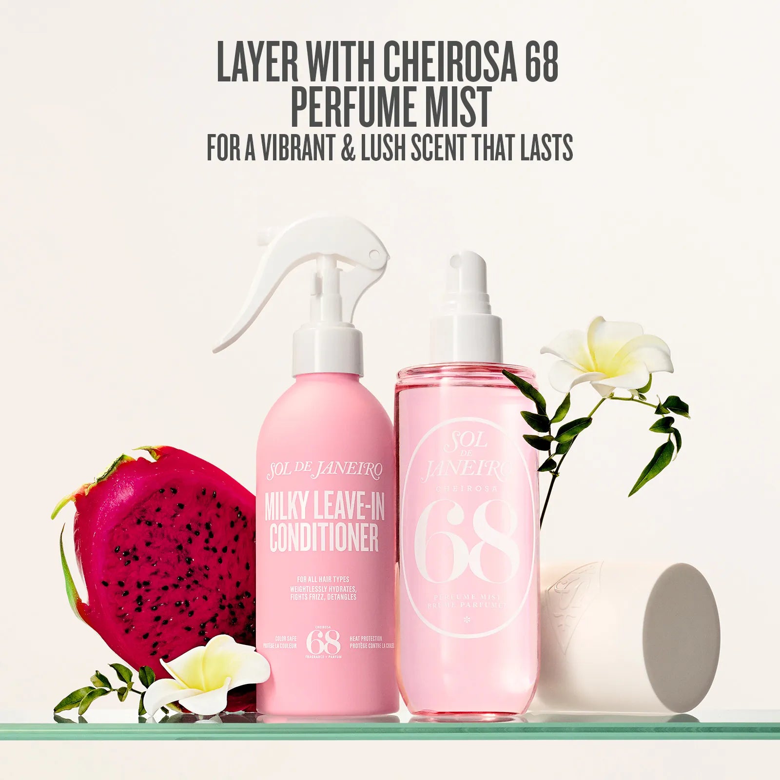 Two pink bottles of skincare products with dragon fruit and flowers on a white background