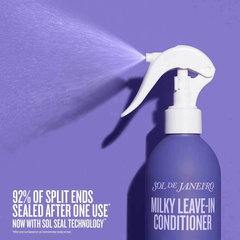 Purple spray bottle of Sol de Janeiro Milky Leave-In Conditioner with a white nozzle on a purple background.