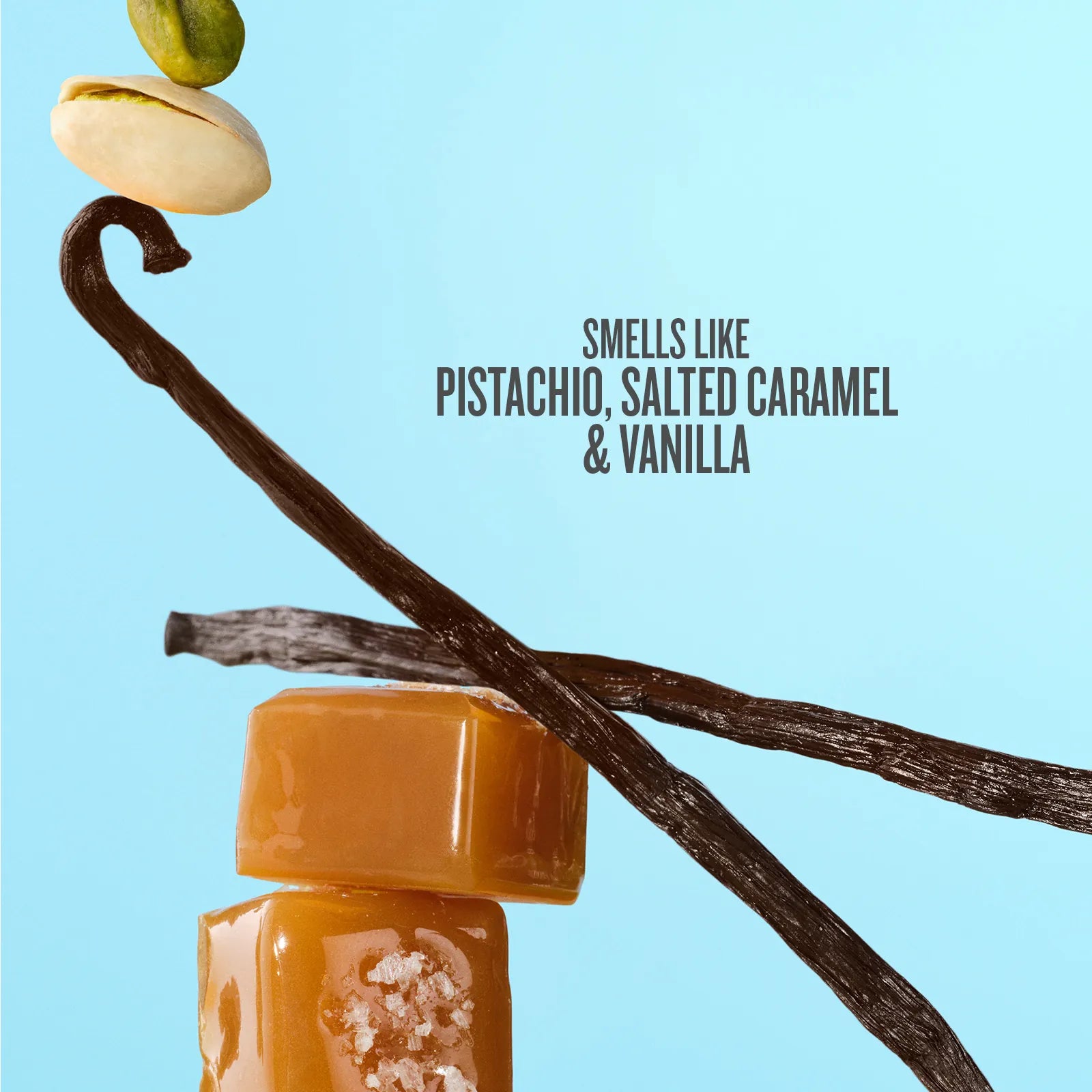 Vanilla extract bottle with vanilla beans and pistachios on a light blue background