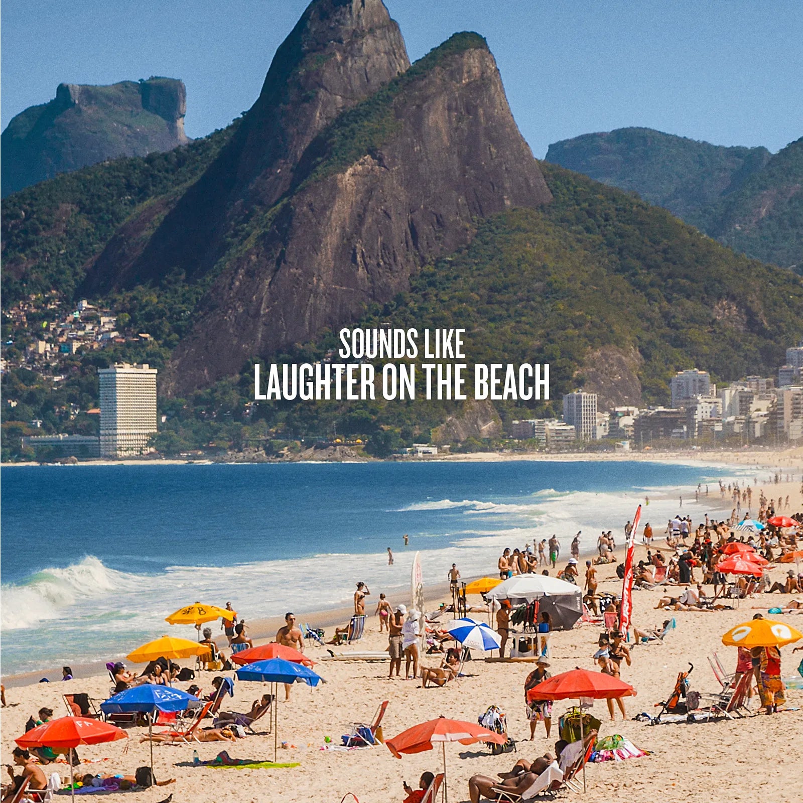 Beach scene with people, umbrellas, and mountains in the background