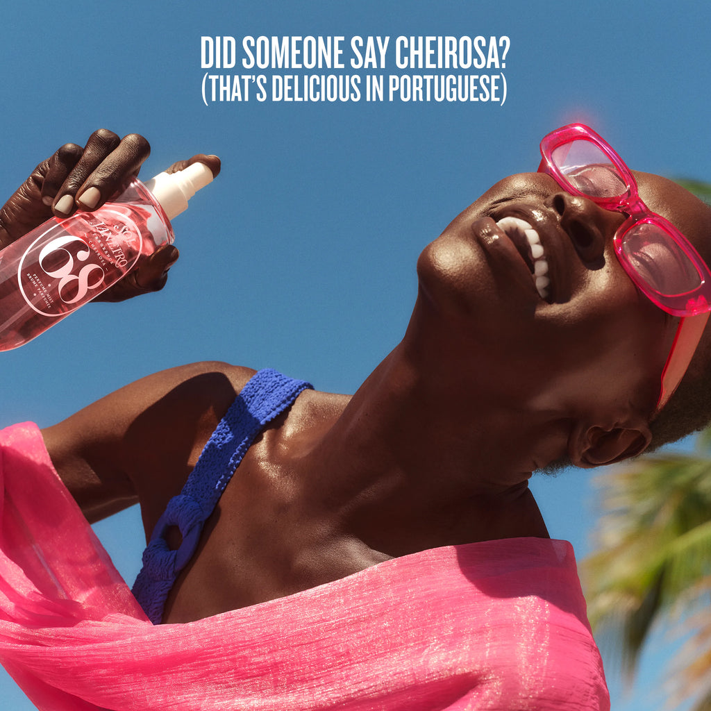 Person wearing pink sunglasses and blue bikini top, with a bottle labeled 'C6' against a clear blue sky.