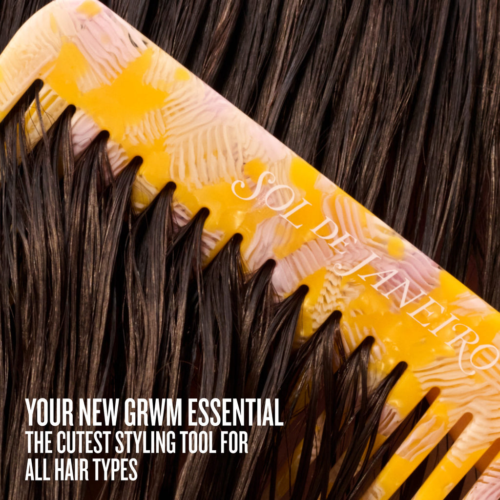 Yellow hairbrush with brown hair being combed, featuring 'Sol de Janeiro' branding.