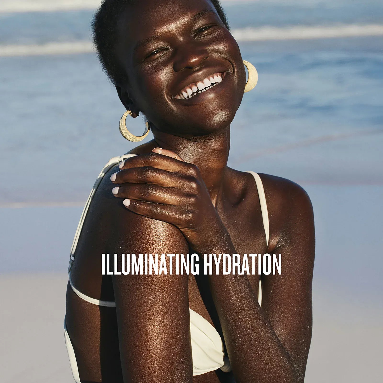 Woman with glowing skin on a beach, with 'ILLUMINATING HYDRATION' text overlay.