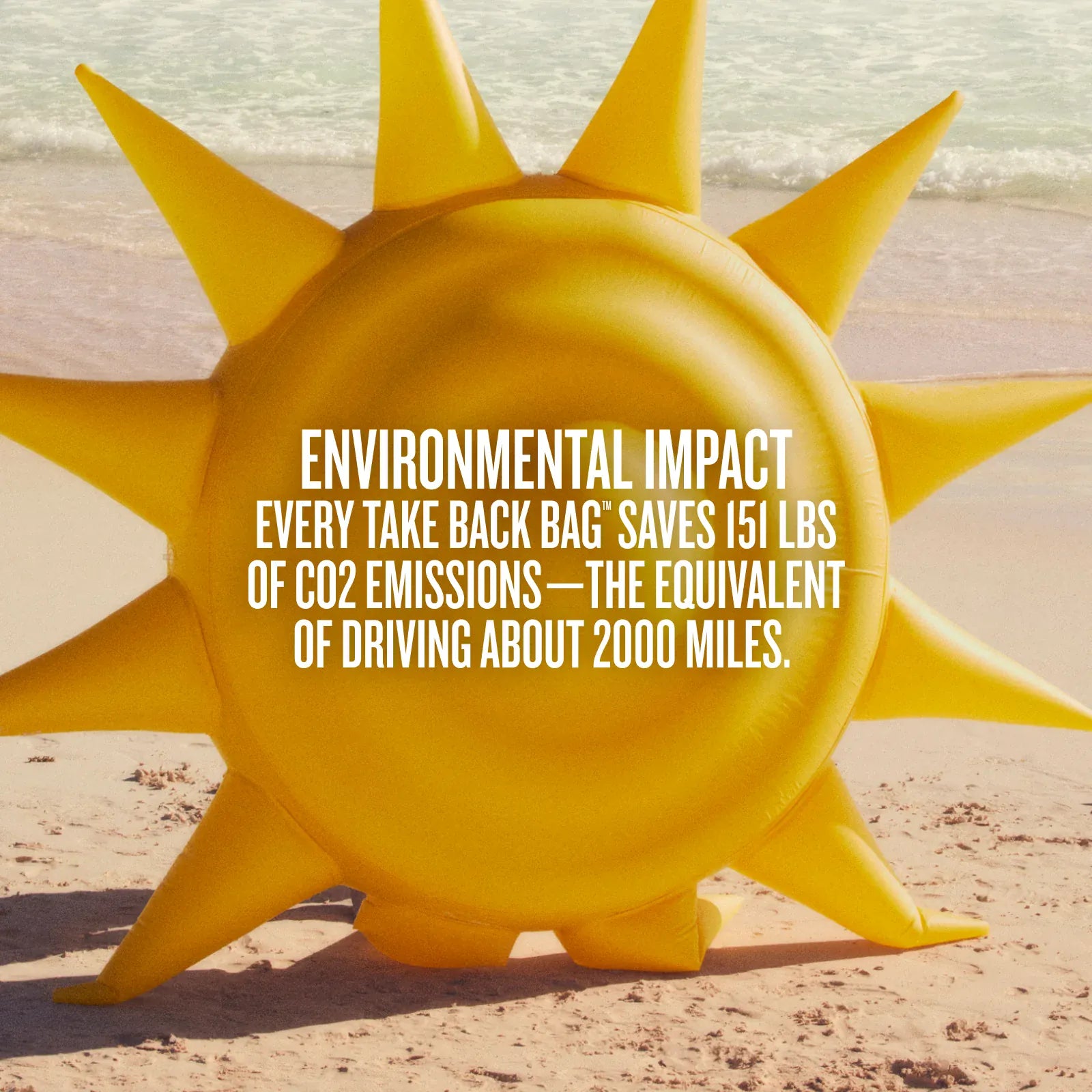 Yellow sun-shaped object on a beach with text about environmental impact.